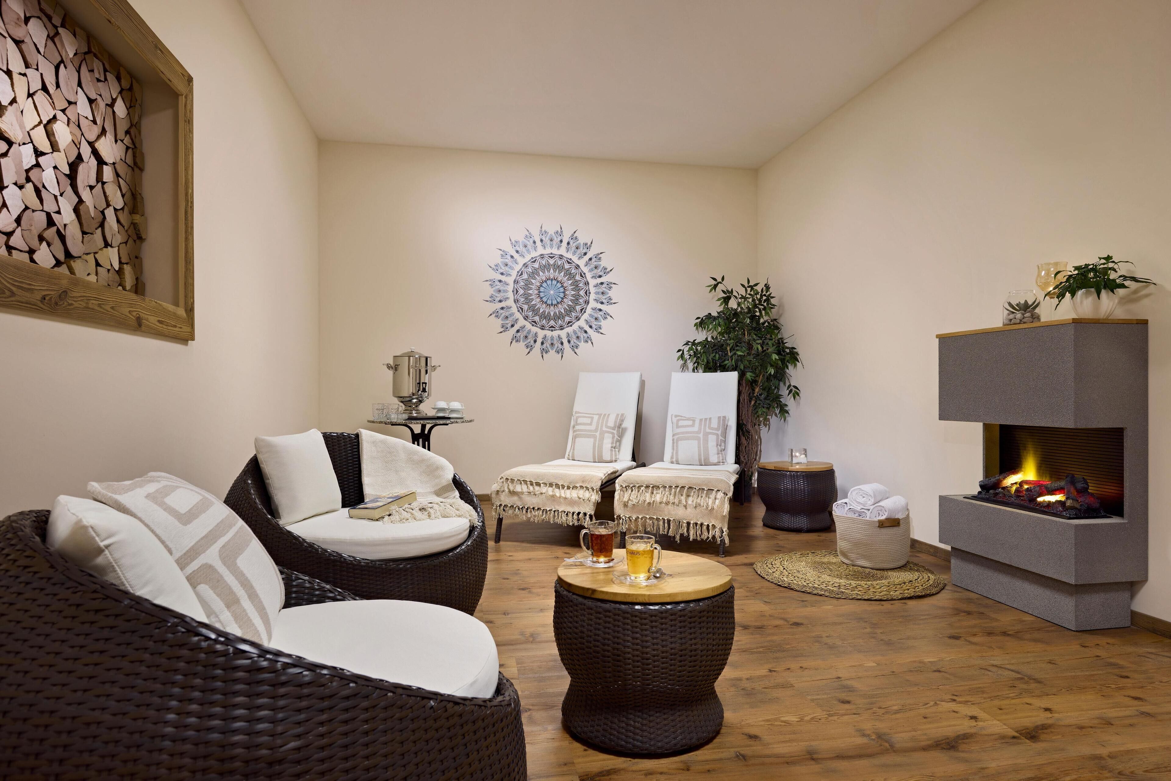 A cozy living room with wicker furniture, a fireplace, and a decorative wall piece.