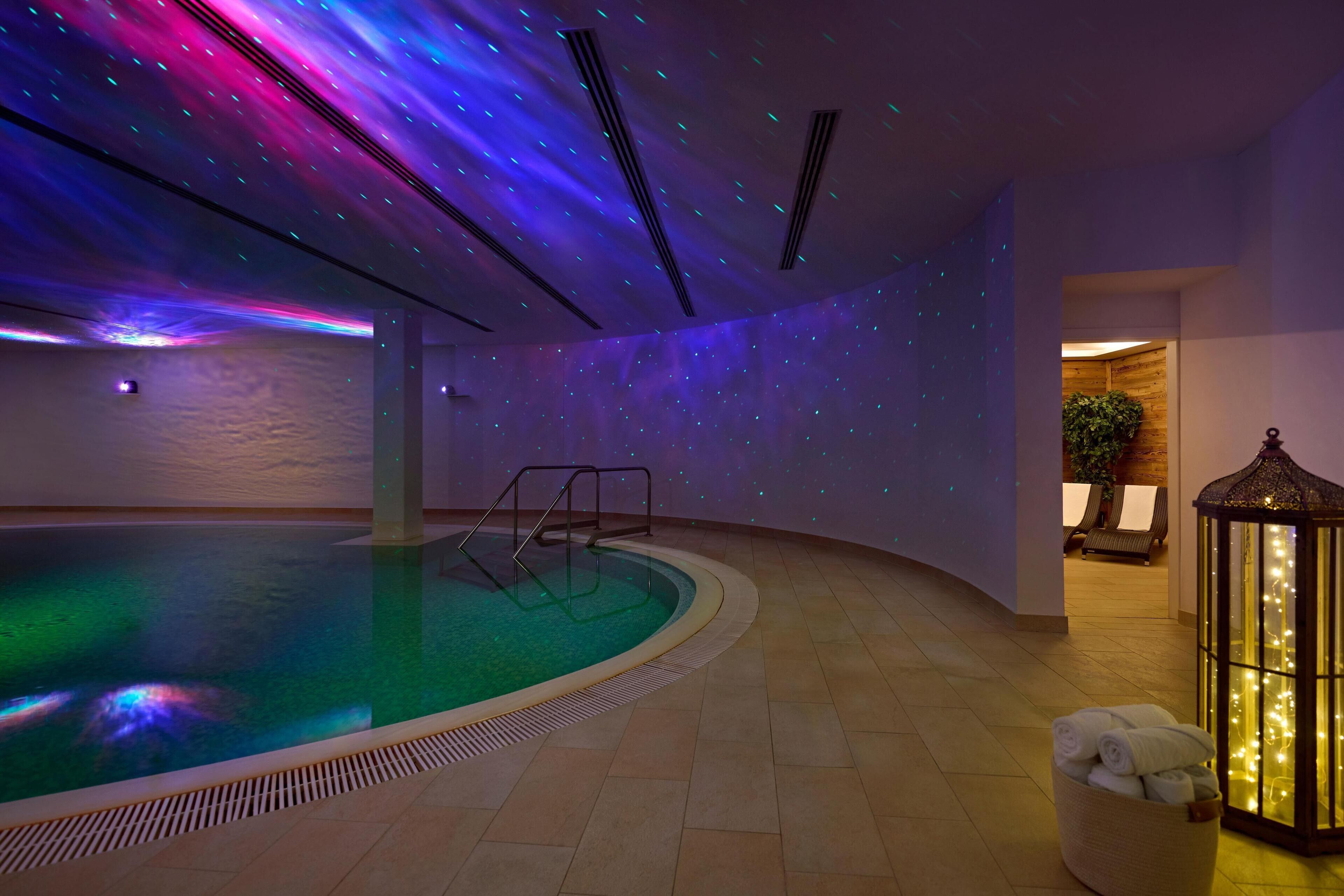 Ein Innenpool mit Sternenhimmel-Projektion, eine Lounge mit Sesseln und eine Laterne.
