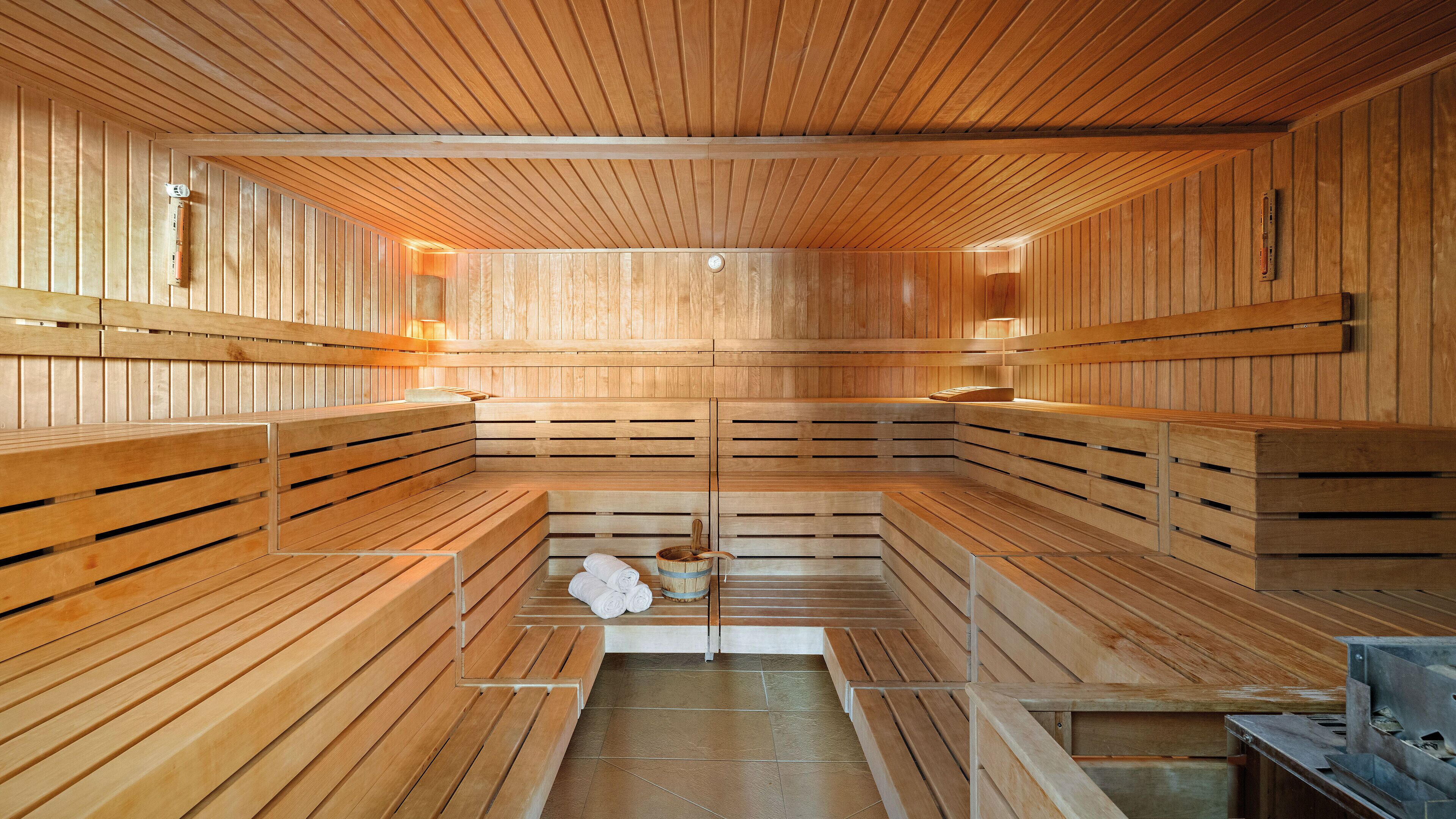 Un sauna avec des bancs en bois et une zone de chauffage centrale.
