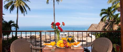 A table with breakfast items and a view of the beach.