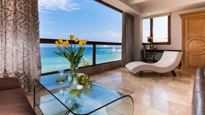 A modern living room with a glass table, a sofa, and a view of the sea. - Vallarta Shores Beach Hotel (Puerto Vallarta)