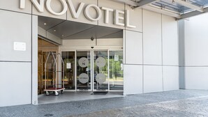 The exterior of a hotel with a modern design, featuring large glass doors and a clear sign reading "NOVOTEL". - Novotel Monterrey Valle (San Pedro Garza García)