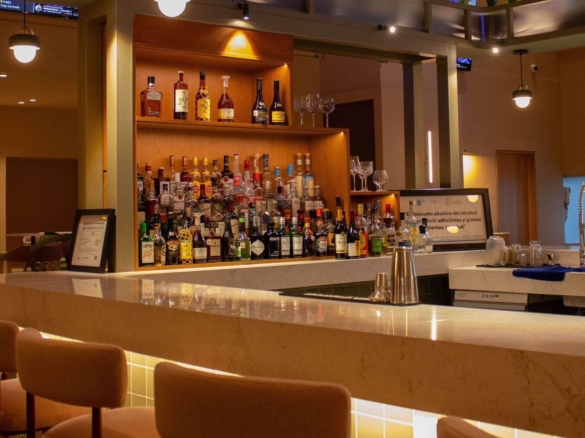 A bar area with a variety of liquor bottles and glasses.