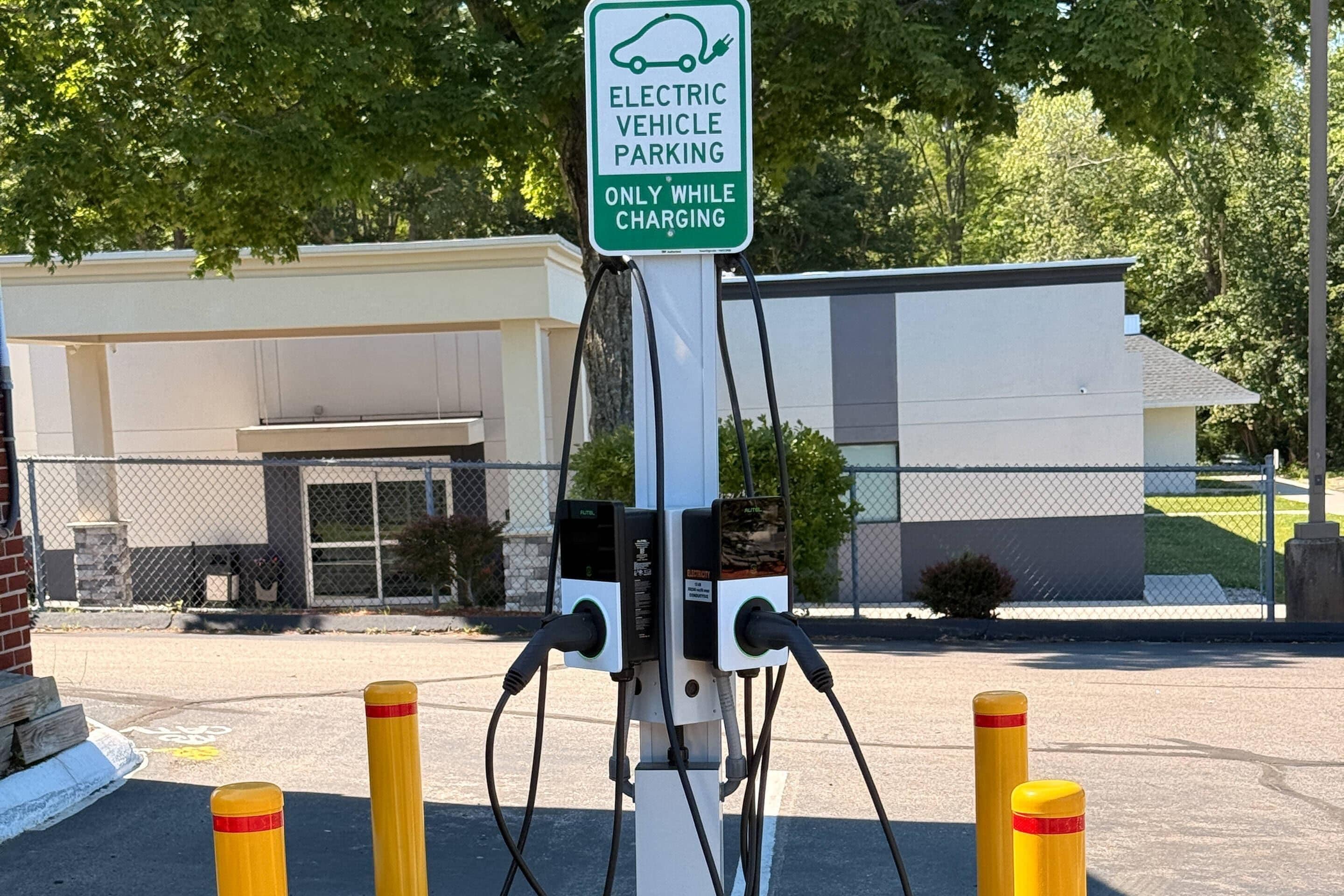 Une borne de recharge pour véhicules électriques, avec un panneau indiquant qu’elle est réservée aux véhicules électriques pendant la recharge.