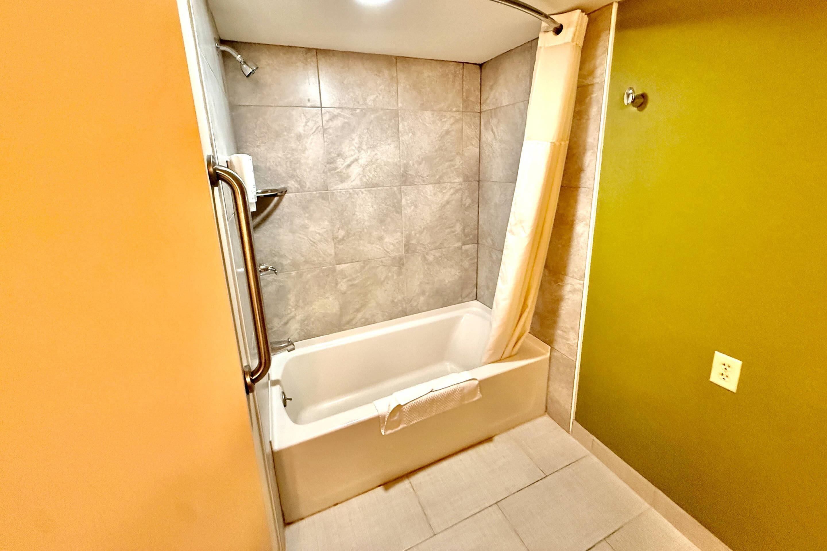 Un baño con bañera, ducha y retrete.