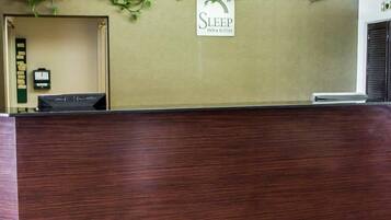 A reception desk with a sign that reads 'SLEEP Inn & Suites.'