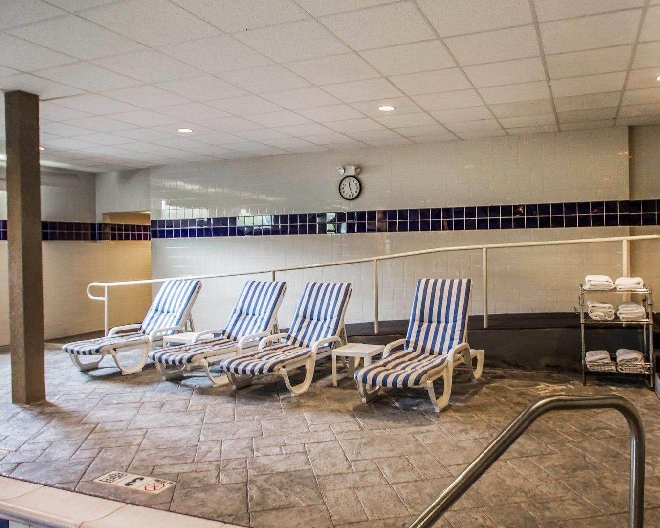 Un espace piscine avec des chaises longues et une horloge au mur.