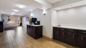 A modern kitchen with dark cabinetry, a white countertop, and a built-in sink. - Red Roof Inn Columbia, SC Airport (West Columbia)