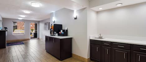 A modern kitchen with dark cabinetry, a white countertop, and a built-in sink.