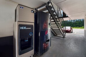 A parking garage with a Pepsi dispenser and an ICE dispenser.