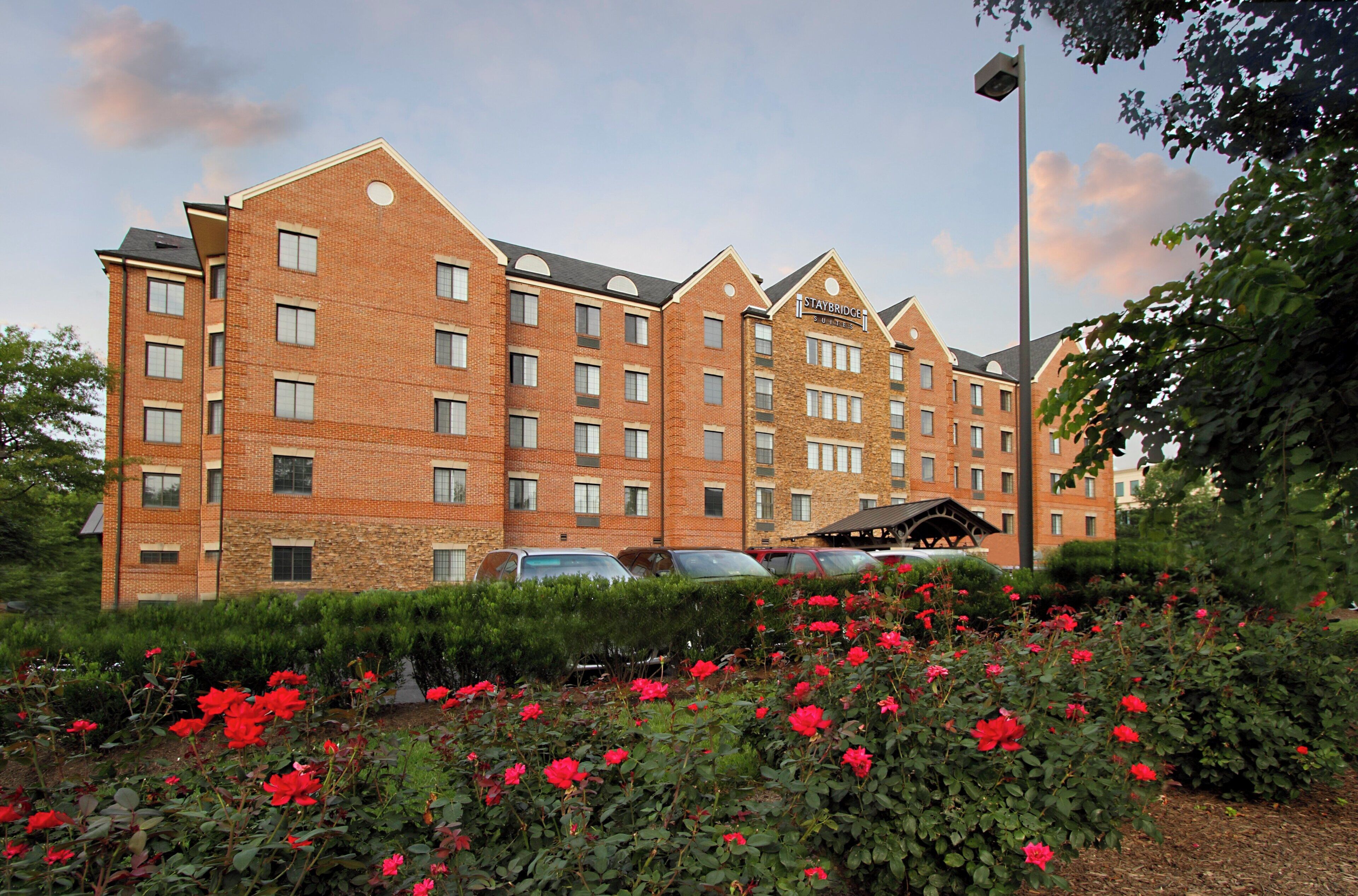 A multi-story hotel with a brick facade, multiple windows, and a sign indicating it is a Staybridge Suites hotel.