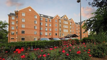 A multi-story hotel with a brick facade, multiple windows, and a sign indicating it is a Staybridge Suites hotel.