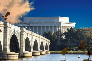 A large white building with a flat roof and columns, a bridge with arches, and a body of water in the foreground. - Staybridge Suites Tysons - McLean by IHG (McLean)