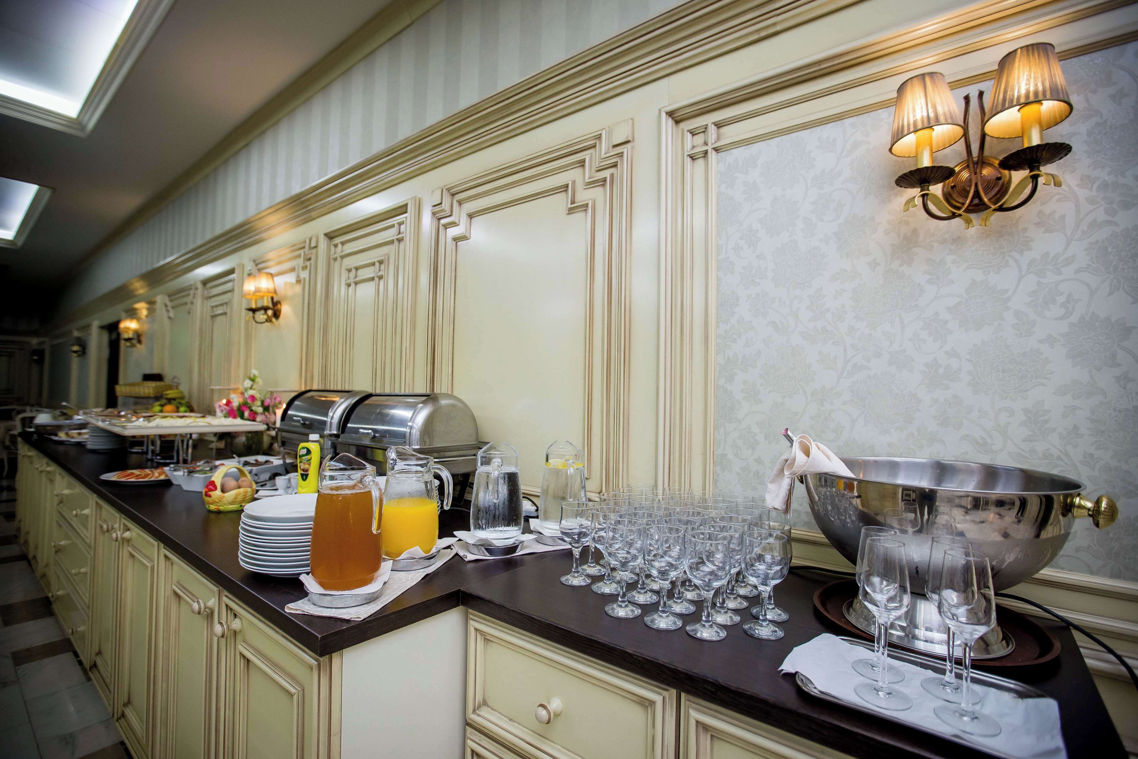 A hotel breakfast buffet with a variety of food items, a coffee machine, and a large bowl for serving.