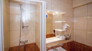 Een badkamer met een douche met glazen wand, een wastafel en een toilet.