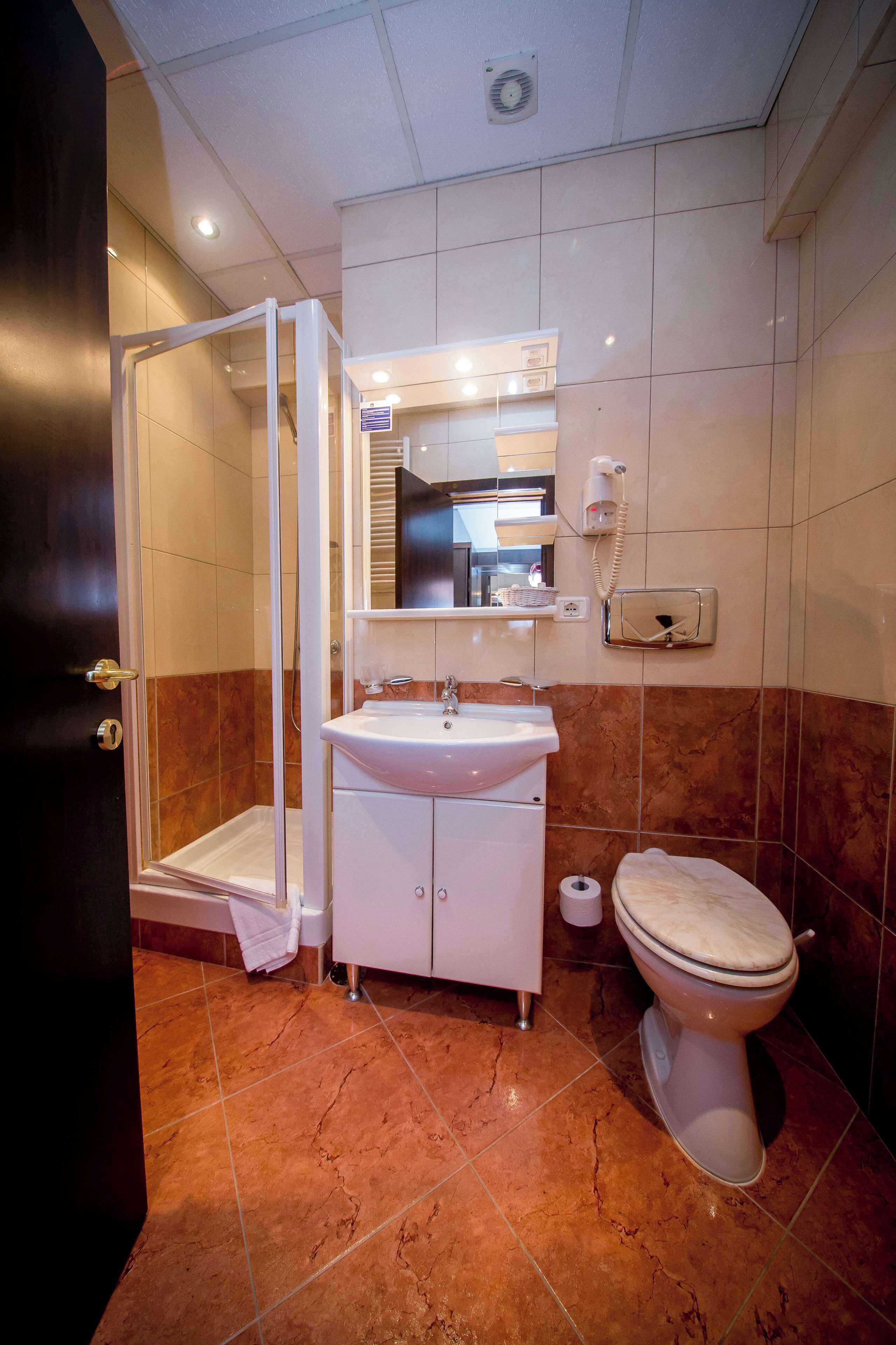 Une salle de bain avec une douche à parois de verre, un lavabo, des toilettes et un miroir.