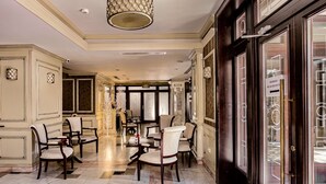 A hotel lobby with a marble floor, multiple dining tables, and chairs. - Best Western Central Hotel (Arad)