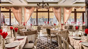 A dining area with tables set for service, large windows with curtains, and a chandelier. - Best Western Central Hotel (Arad)