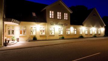 Vista frontal de la propiedad por la tarde o noche