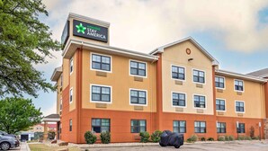 Un hotel Stay America con un diseño moderno, con varios pisos y un letrero llamativo.