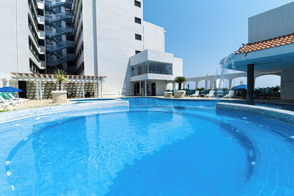 Una piscina al aire libre, tumbonas
