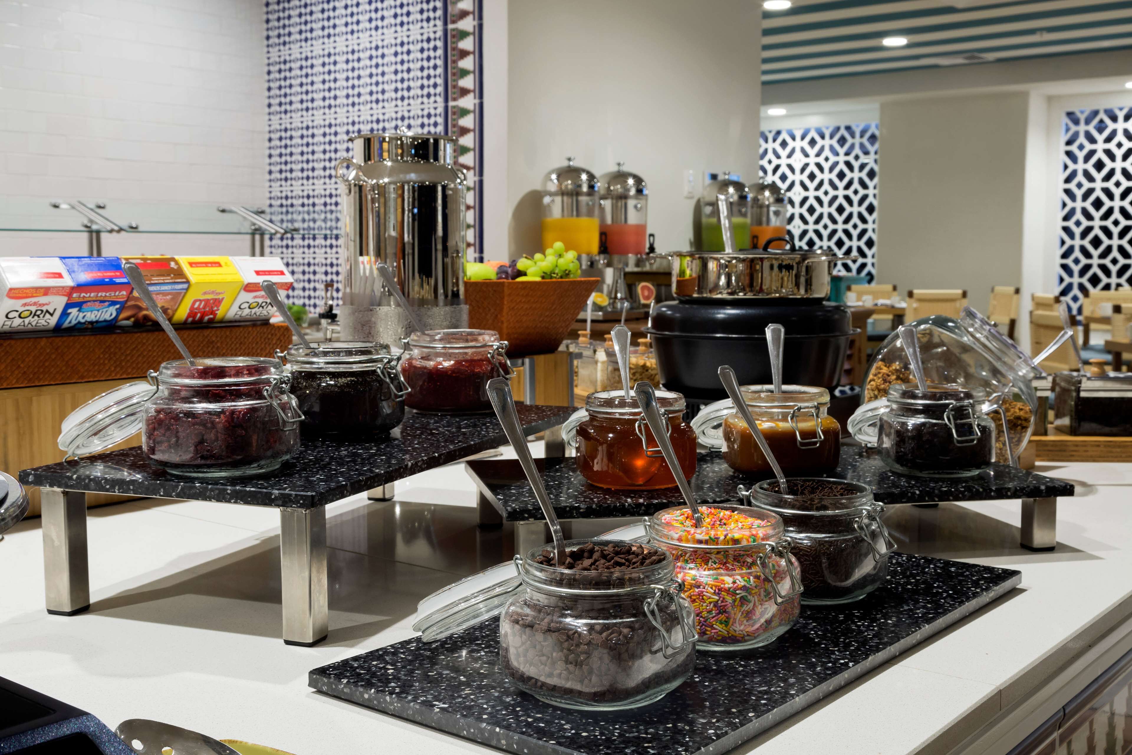 Una mesa de buffet con diversos alimentos y salsas.