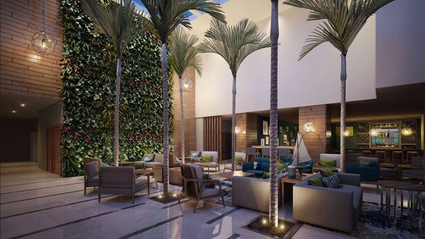 A modern indoor lounge area with seating arrangements, a bar area, and a wall with vertical greenery. - DoubleTree by Hilton Hotel Veracruz (Veracruz)