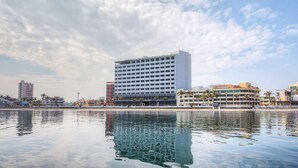 A modern hotel with a large building and a waterfront view. - DoubleTree by Hilton Hotel Veracruz (Veracruz)