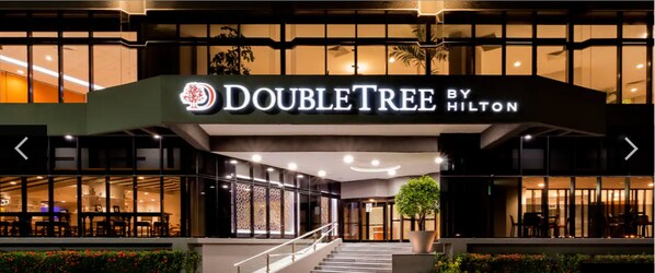 The exterior of the DoubleTree by Hilton hotel with a modern design, featuring a prominent entrance, glass doors, and a staircase leading to the lobby. - DoubleTree by Hilton Hotel Veracruz (Veracruz)