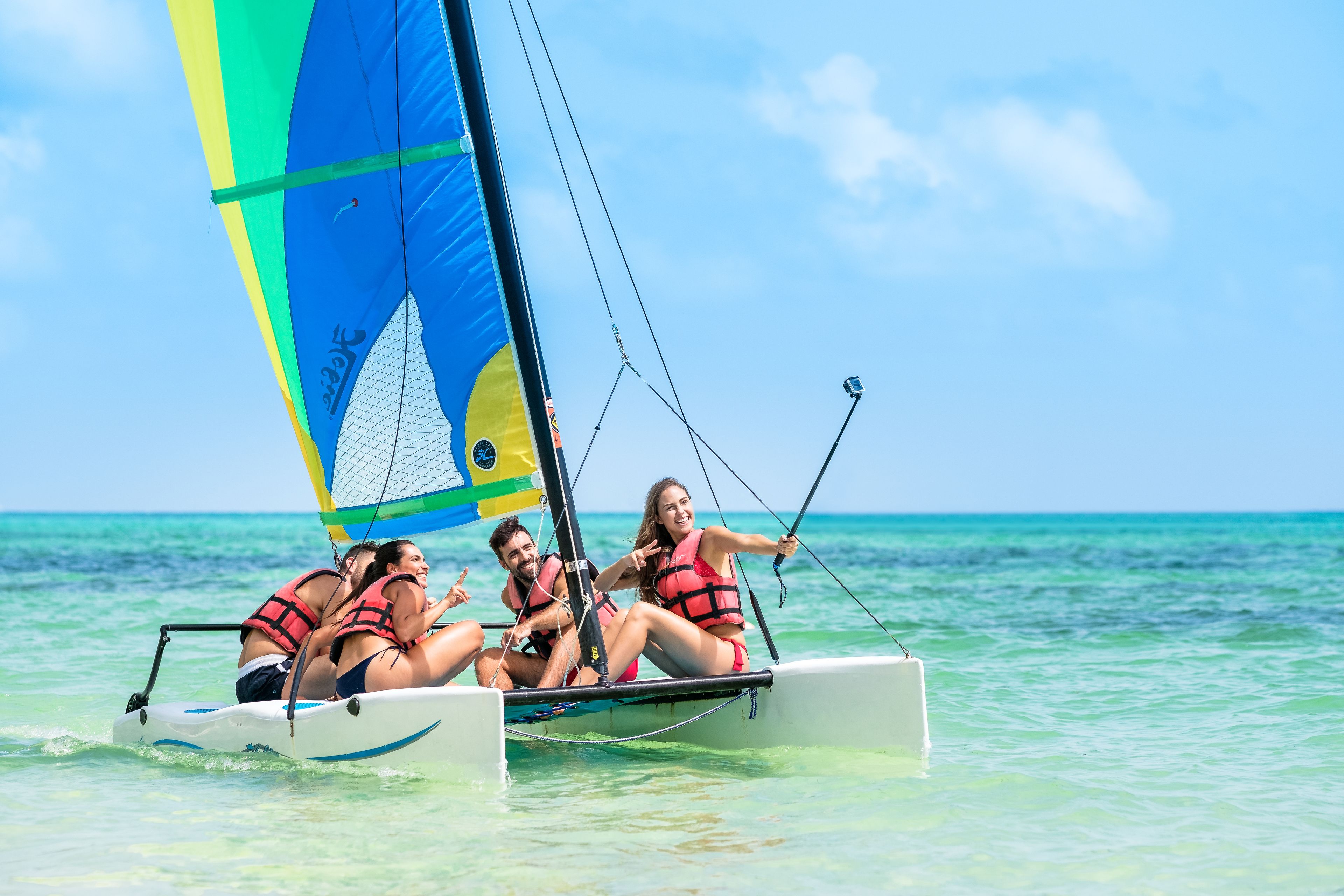 A sailboat with passengers wearing life jackets.