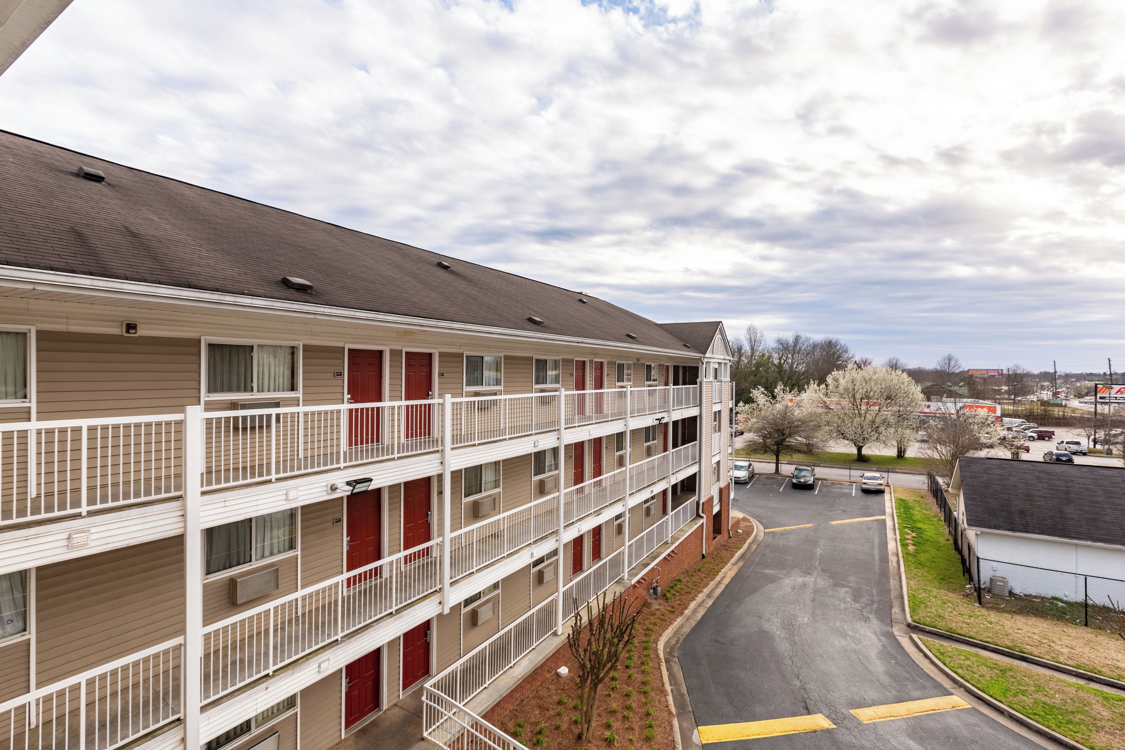 Un motel à plusieurs étages avec un parking et une route au premier plan.