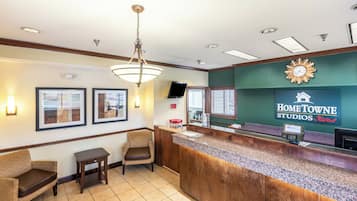 A reception area with a counter, framed pictures, a clock, and a sign for HomeTOWNE Studios.