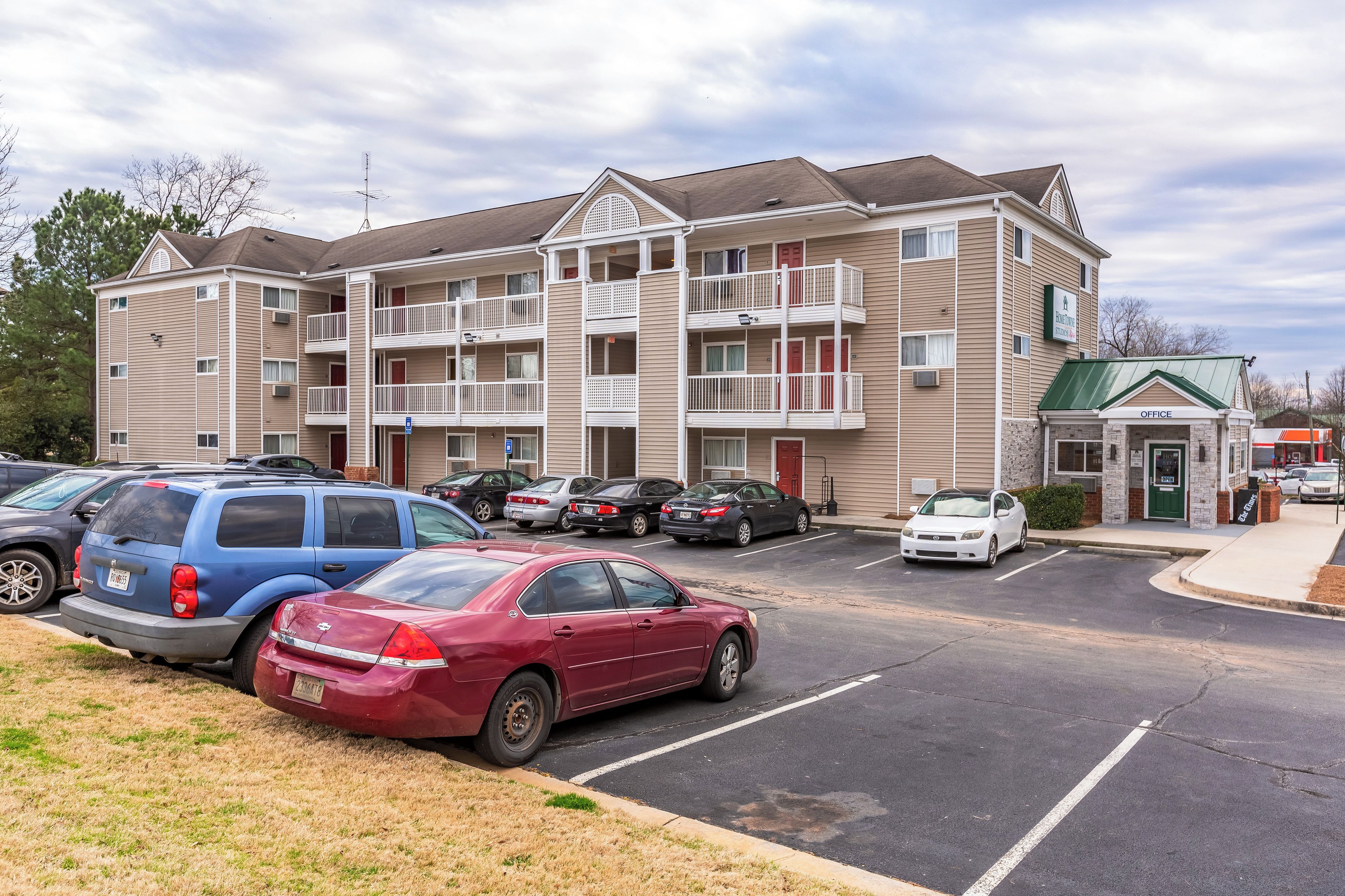 A multi-story apartment building with a parking lot in front.