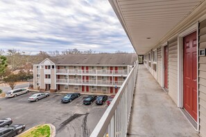 A multi-story motel with a parking lot, a covered walkway, and a view of the surrounding area.