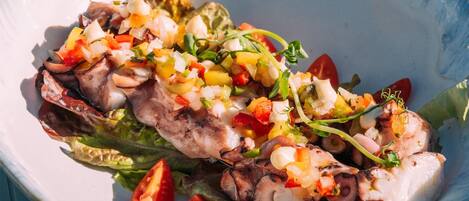 A bowl of food with grilled meat, vegetables, and a creamy sauce.