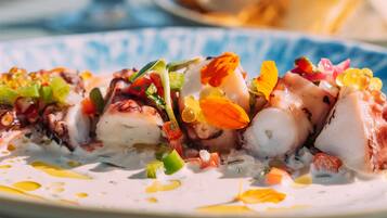 Ensalada de pulpo con diversas verduras y adornos.