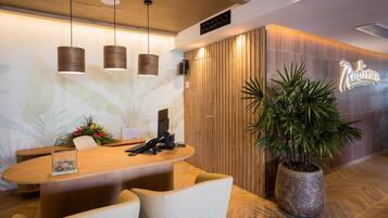 A reception desk with a wooden finish, a potted plant, and a sign that reads "Radisson."