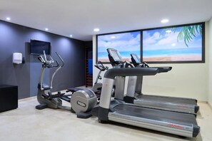 A gym with treadmills, an elliptical, and a stationary bike. - Catalonia Barcelona Beach (Barcelona)
