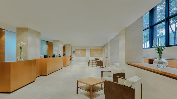 A spacious lobby with a reception desk, seating area, and large windows. - Catalonia Barcelona Beach (Barcelona)