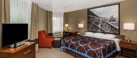 Una habitación de hotel con cama, televisión, escritorio y silla.