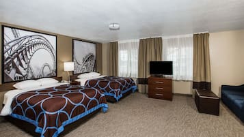Une chambre d’hôtel avec deux lits, une télévision, une commode et une grande fenêtre avec des rideaux.