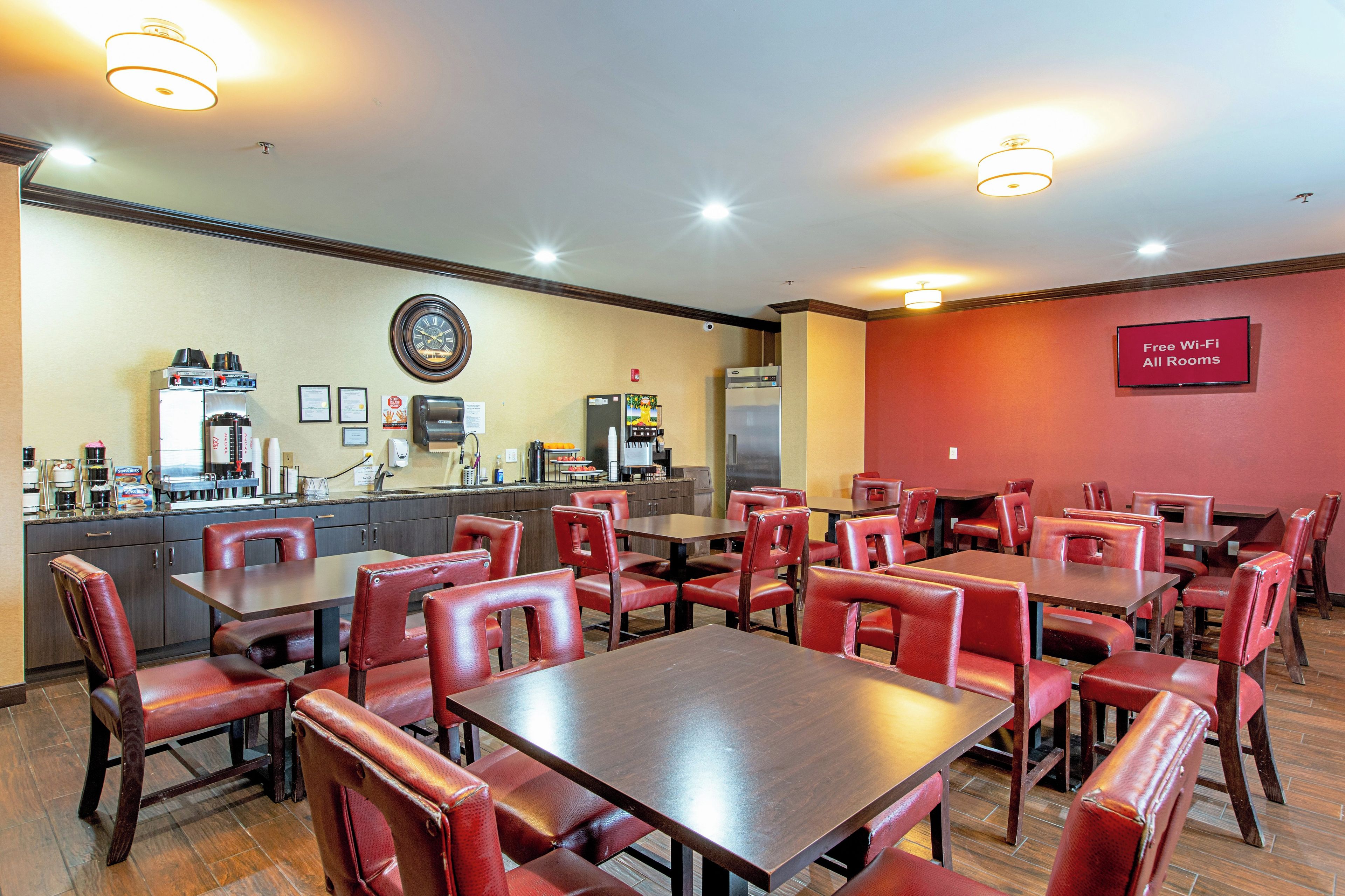 Un restaurant doté de plusieurs tables et chaises, d’une machine à café et d’un panneau indiquant que le Wi-Fi est disponible gratuitement.