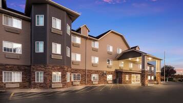 A multi-story hotel with a stone facade, multiple balconies, and a parking lot.