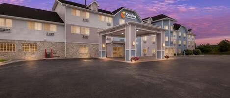 Un hôtel Comfort Inn & Suites doté d’une entrée couverte et d’une façade en pierre.