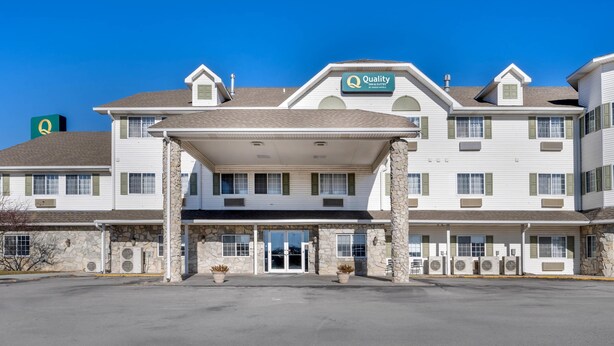 A hotel with a covered entrance, multiple windows, and a sign indicating it is a Quality Inn.