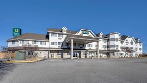 A multi-story hotel with a covered entrance and a parking lot.