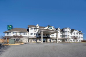 A multi-story hotel with a covered entrance and a parking lot.