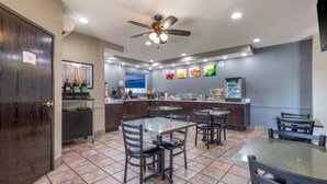 A restaurant with a counter, tables, chairs, a ceiling fan, and a tiled floor.