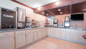 Eine Küche mit einem großen Kühlschrank, einer Kaffeemaschine und einer Mikrowelle.