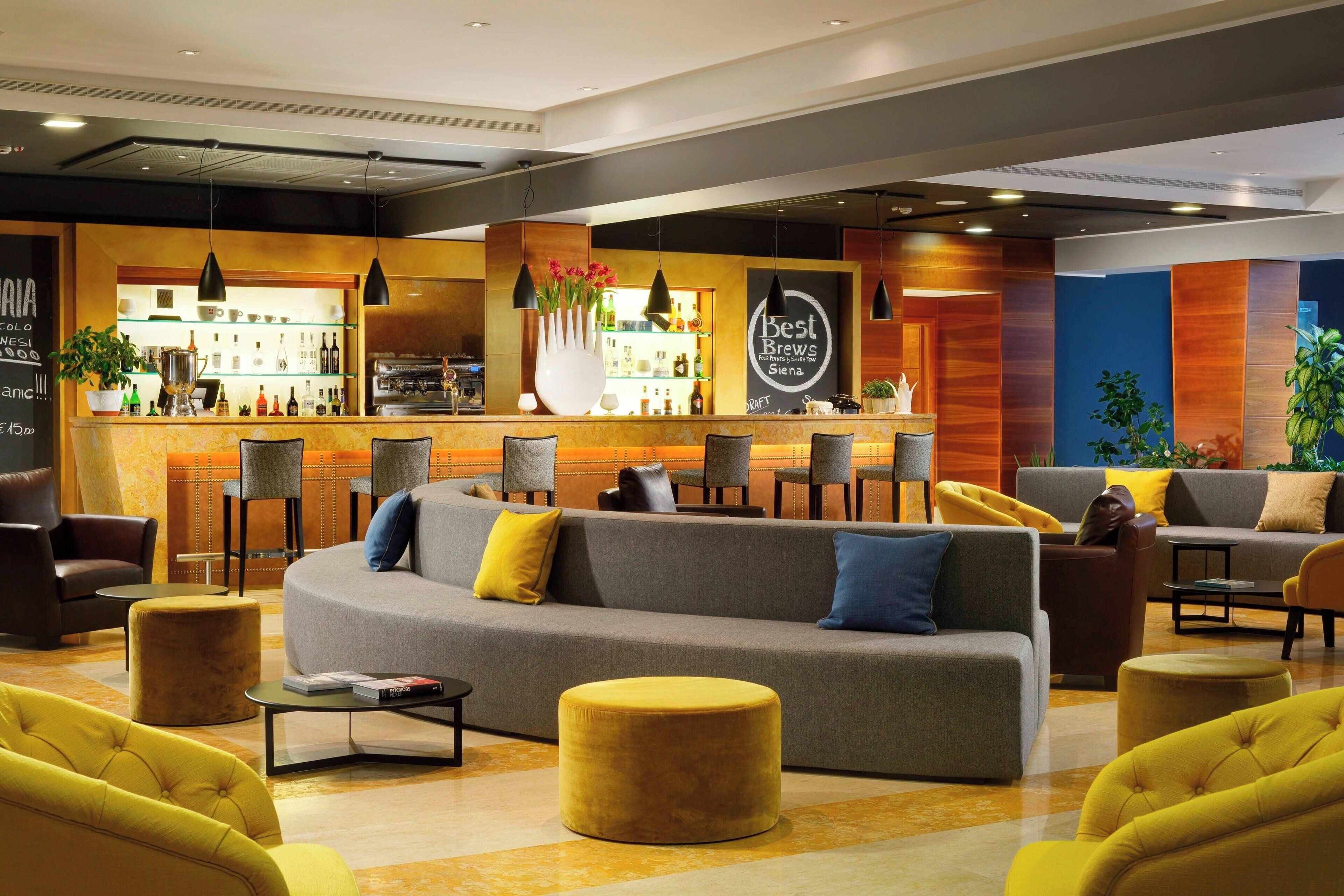 Un área de estar moderna con un bar, sofás y sillones.
